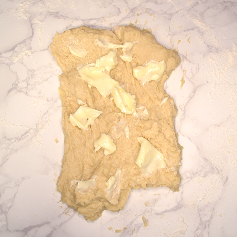 adding butter to the dough